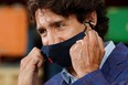 Canada's Prime Minister Justin Trudeau removes his face mask before speaking at the 3M's plant in Brockville, Ont. on Friday, Aug. 21, 2020.