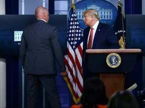 President Donald Trump is removed by a member of the secret service from the Brady Briefing Room of the White House in Washington, on August 10, 2020.
