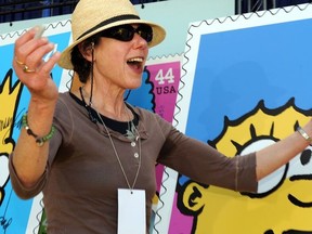 Actress Julie Kavner (voice of Marge Simpson) poses next to the unveiled stamps of Simpsons characters at the Fox Studios in Los Angeles, California, on May 7, 2009, during a dedication ceremony for the first day of issue of the stamps by the US Postal Service.