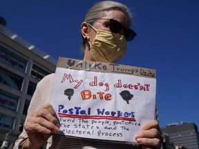 A woman holds a sign during a news conference about the United States Postal Service (USPS) in the Manhattan borough of New York City, New York, U.S., August 18, 2020.