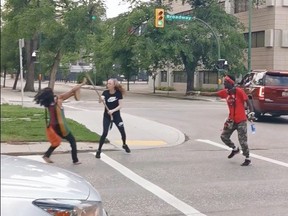 A pair of people who participated in a protest on July 4, 2020 and were walking east on Broadway Avenue in Winnipeg were attacked by a woman with a hockey stick, as shown in this screengrab from a Facebook video.