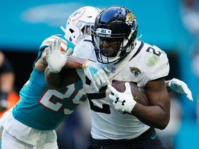Leonard Fournette of the Jacksonville Jaguars tries to avoid the tackle of Minkah Fitzpatrick of the Miami Dolphins in the second half at Hard Rock Stadium on December 23, 2018 in Miami, Florida.