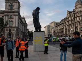 The statue of Sir Winston Churchill is seen vandalized with spray paint as an Extinction Rebellion protest takes place in Parliament Square on Sept. 10, 2020 in London.