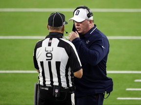 Dallas Cowboys head coach Mike McCarthy talks with line judge Mark Perlman during Sunday night's game against the Rams.