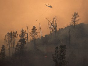 A helicopter and crew releases water to extinguish a section of the LNU Lightning Complex Fire near Middletown, California, Aug. 24, 2020.