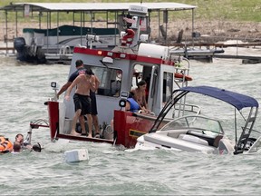 Boats partially submerged from the large wakes of a flotilla of supporters of U.S. President Donald Trump, float in distress during a boat parade on Lake Travis near Lakeway, Texas,  Sept. 5, 2020.