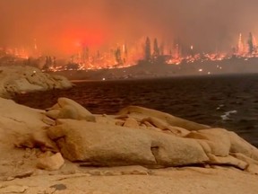 A fire surrounds Mammoth Pool Reservoir in Calif., Sept. 5, 2020 in this screen grab obtained from a social media video.