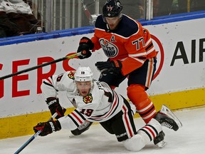 Chicago Black Hawks Jonathan Toews (left) is checked by Edmonton Oilers Oscar Klefbom during NHL hockey game action in Edmonton on Tuesday February 11, 2020.