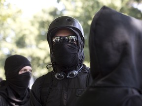 Antifa protesters wear bandanas over their face during a protest to oppose a  right wing group that was having a rally in downtown Portland, Oregon on September 10, 2017.