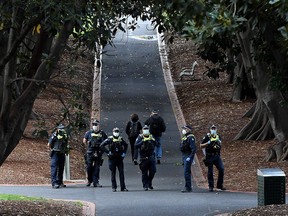Police patrol through Treasury Gardens in Melbourne on September 26, 2020, as the state of Victoria waits to hear of a lifting of social.