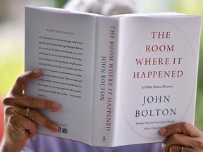 This file illustration photo taken on June 23, 2020 in Glendale, California, shows a woman reading John Bolton's book "The Room Where it Happened" on the day of its release in Los Angeles.