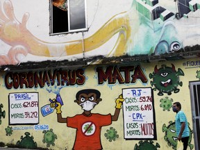 A man walks past a graffiti art with outdated coronavirus disease (COVID-19) statistics in Alemao slums complex in Rio de Janeiro, Brazil, Sept. 16, 2020.