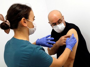 A health worker injects an experimental COVID-19 vaccine to volunteer and doctor Naim Celik as Turkey began final Phase III trials at Kocaeli University Research Hospital in Kocaeli September, 25, 2020.