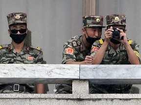 North Korean soldiers wearing masks look at the South on September 16, 2020 in Panmunjom, South Korea.