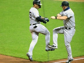 Yankees shortstop Gleyber Torres (25) celebrates with third base coach Phil Nevin (88) after hitting a two-run home run against the Indians in the fifth inning at Progressive Field in Cleveland, Tuesday, Sept. 29, 2020.