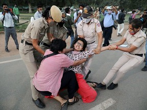 A demonstrator is detained by police during a protest after the death of a rape victim, on Rajpath near India Gate, in New Delhi, India, September 30, 2020.