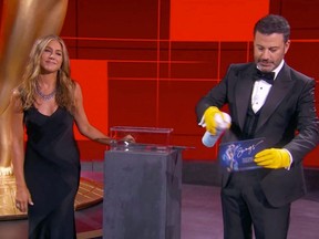 This handout screen shot shows host Jimmy Kimmel and actress Jennifer Aniston disinfecting ballots during the 72nd Primetime Emmy Awards held virtually on Sunday, Sept. 20, 2020.