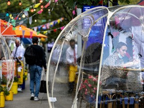 A woman sits outside Cafe Du Soleil under bubble tents following the outbreak of the coronavirus in New York  September 23, 2020.