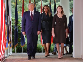 President Donald Trump, first lady Melania Trump and 7th U.S. Circuit Court Judge Amy Coney Barrett walk into the Rose Garden before Trump announces Barrett as his nominee to the Supreme Court at the White House September 26, 2020.
