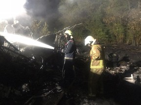 This handout picture taken and released by the State Emergency Service of Ukraine on September 25, 2020 shows firefighters working on the place of the Antonov-26 transport aircraft crash at Chuhuiv military air base.
