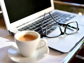 A picture taken on March 15, 2020 shows glasses on a laptop at a home office desk.