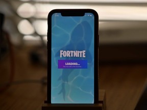 This file illustration photo taken on August 14, 2020 shows Epic Games' Fortnite loading on a smartphone in Los Angeles on August 14, 2020.