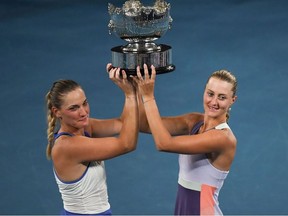 In this file photo taken on January 31, 2020 Hungary's Timea Babos (L) and France's Kristina Mladenovic (R) pose with the championship trophy during the awards ceremony after their victory against Taiwan's Hsieh Su-wei and Czech Republic's Barbora Strycova during the women's doubles final on day twelve of the Australian Open tennis tournament in Melbourne.