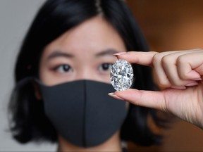 A Sotheby's employee hold a 102.39-carat D Colour Flawless Oval Diamond during a media preview at Sotheby's on Sept. 9, 2020 in New York City.