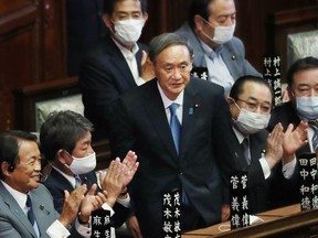 Members of the Lower House applaud after Japan's Liberal Democratic Party (LDP) leader Yoshihide Suga (C) was elected as Japan's new prime minister in parliament in Tokyo on September 16, 2020.