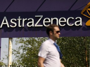 A man walks past a sign at an AstraZeneca site in Macclesfield, England May 19, 2014.