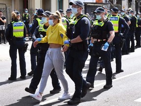 Police detain an anti-lockdown protester at Melbourne's Queen Victoria Market during a rally on September 13, 2020, amid the ongoing COVID-19 coronavirus pandemic.