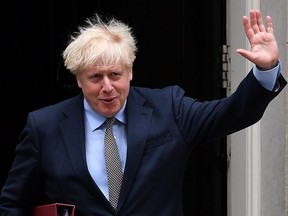 Britain's Prime Minister Boris Johnson waves as he leaves 10 Downing Street in London on Wednesday, Sept. 9, 2020, to attend Prime Minister's Questions at the House of Commons.
