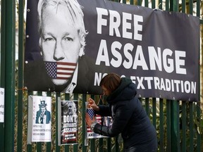 A supporter of WikiLeaks founder Julian Assange posts a sign on the Woolwich Crown Court fence, ahead of a hearing to decide whether Assange should be extradited to the United States, in London, Britain February 25, 2020.