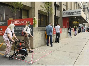 People wait in line for hours at a COVID assessment centre at Mount Sinai Hospital during the COVID-19 pandemic in Toronto on Thursday, Sept. 24, 2020.
