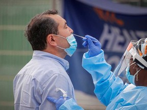 A health worker takes a swab sample from a man to test for COVID-19 in the Borough Park area of Brooklyn, New York, Sept. 25, 2020.