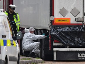In this file photo taken on October 23, 2019 forensics officers work on a lorry, found to be containing 39 dead bodies, at Waterglade Industrial Park in Grays on October 23, 2019.