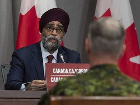 Chief of Defence Staff Jonathan Vance, right, looks on as National Defence Minister Harjit Sajjan makes his opening remarks at a news conference in Ottawa, Friday, June 26, 2020.