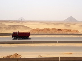 A truck moves past as a new superhighway cuts across desert within a view of the Red Pyramid, the world's third tallest and the Bent Pyramid behind in Giza, Egypt September 5, 2020.