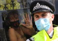 A climate activist shows her hand as she sits inside a police van after being detained during an Extinction Rebellion protest in London, Sept. 10, 2020.