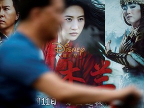 A man rides past an advertisement promoting Disney's movie "Mulan" at a bus stop in Beijing, China September 9, 2020.
