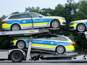 Police cars are seen on a car transporter at a motorway service station near Wilnsdorf, Germany, July 11, 2018.