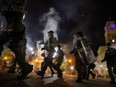 Police officers move past Louisville City Hall to clear protesters from a plaza ahead of a 9pm curfew after a grand jury considering the March killing of Breonna Taylor, a Black medical worker, in her home in Louisville, Kentucky, voted to indict one of three white police officers for wanton endangerment, in Louisville, Kentucky, U.S. September 23, 2020.