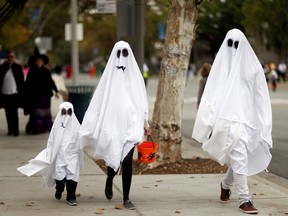 People wearing costumes walk during Halloween in Sierra Madre, Calif., Oct. 31, 2017.