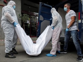 Forensic staff carry a body bag, allegedly containing the remains of Gholamreza Mansouri, outside a hotel in downtown Bucharest, Romania, June 19, 2020.