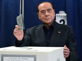 Former Italian PM Silvio Berlusconi looks at photographers as he casts his vote at a polling station in Milan on May 26, 2019.
