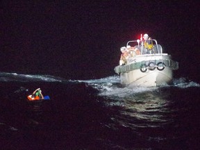 This handout picture taken Wednesday, Sept. 2, 2020 and provided by 10th Regional Coast Guard Headquarters on Thursday, Sept. 3, 2020, shows coast guards rescuing a man off Japan's Amami Oshima island.