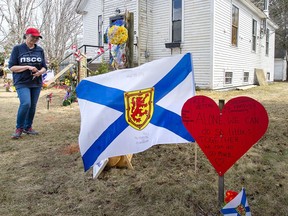 People pay their respects at a roadside memorial in Portapique, N.S. on Sunday, April 26, 2020.