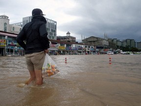 A man wades through a street flooded by Typhoon Maysak in the eastern port city of Gangneung on September 3, 2020.