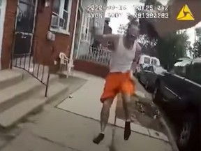 A man runs behind a police officer before being shot in Lancaster, Pennsylvania, in this still image taken from a body camera footage on September 13, 2020.