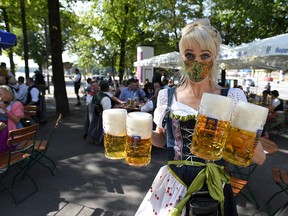 A server carries mugs during a barrel tapping at a beer garden near Theresienwiese where Oktoberfest would have started today as COVID-19 continues in Munich, Germany, September 19, 2020.
